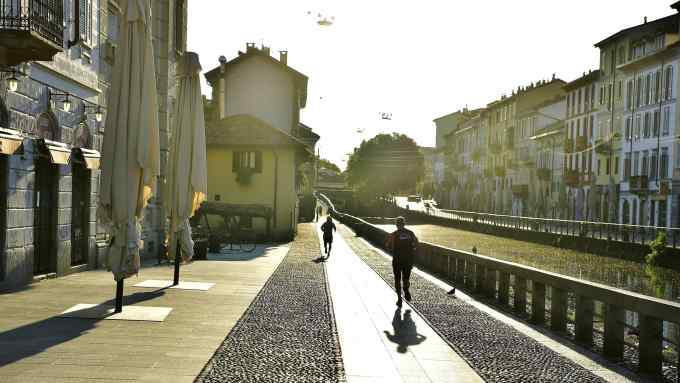Joggers running alongside Milan’s Grand Canal
