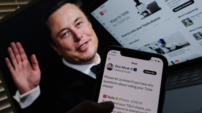 This illustration image created shows Elon Musk’s campaign launched on X ahead of Tesla shareholders meeting in front of his picture on a screen