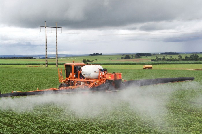Farm vehicle sprays soy crop