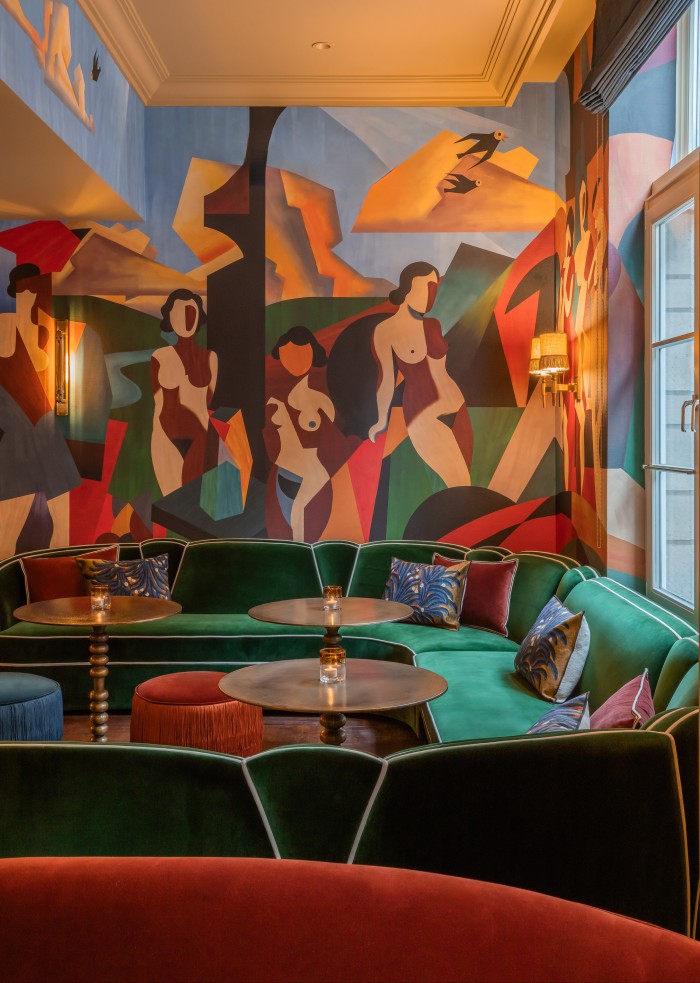 The bar’s abstract murals and velvet settees and chairs