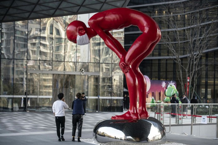 Employees walk past a sculpture on the campus of the Ant Group headquarters in Hangzhou, China