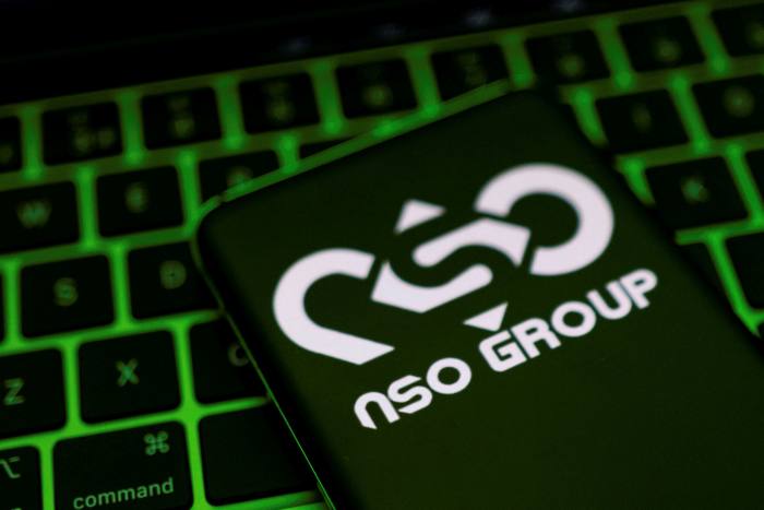 NSO Group logo on a smartphone, which is placed on a keyboard in this illustration