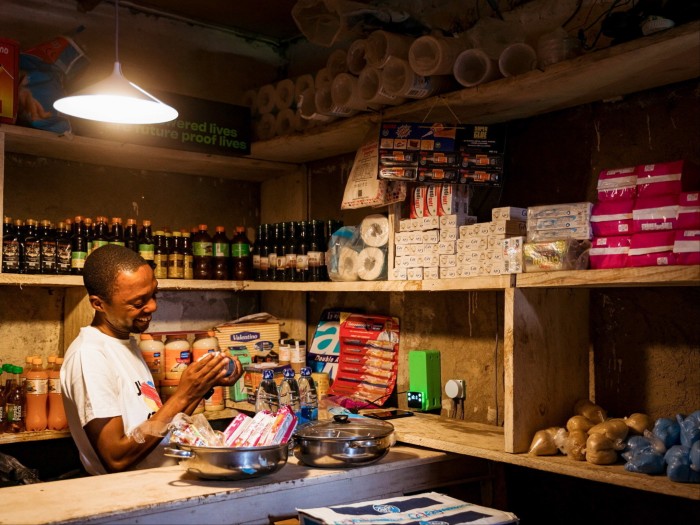 A shop clerk works under a glowing lamp at night