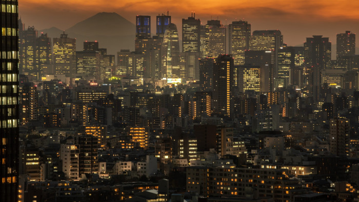 High-rise buildings fill up Tokyo’s skyline at dusk. In the background is Mount Fuji