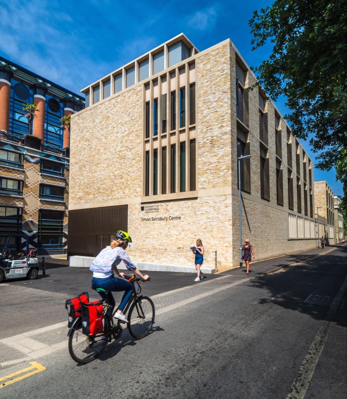 A cyclist passes by the Cambridge Judge business school
