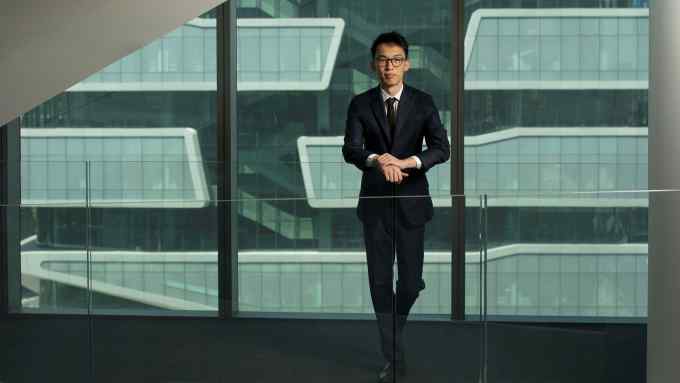 Columbia Business School masters graduate Kevin Guo. A man stands close to a glass wall of a building
