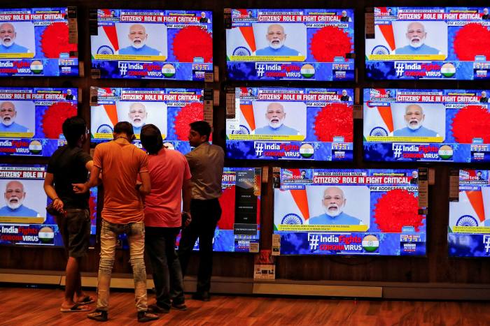 People watch PM Narendra Modi’s speech on TV in March 2020 about India’s response to the spread of coronavirus