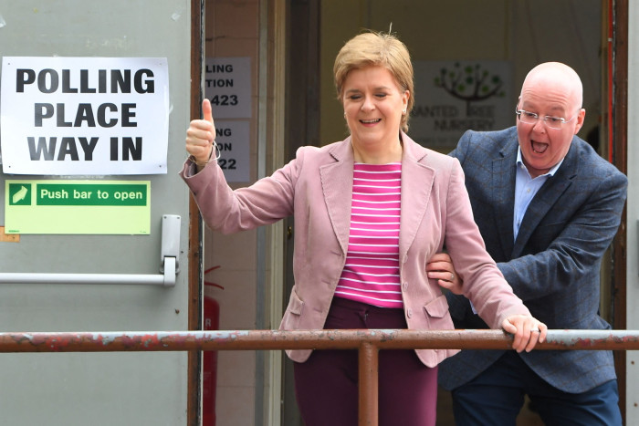 Nicola Sturgeon reacts is surprised by her husband and chief executive officer of the Scottish National Party Peter Murrell, after casting their vote in local elections, at a polling station, in Glasgow in 2022