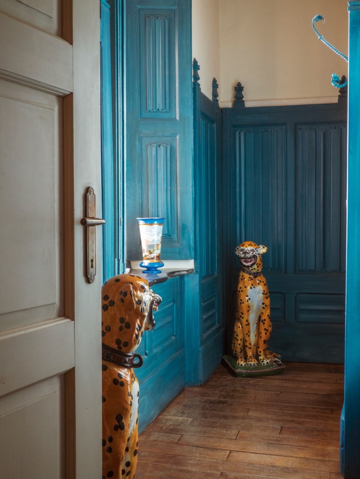 Blue panelling and a pair of leopard statues in the antechamber of the guest bathroom
