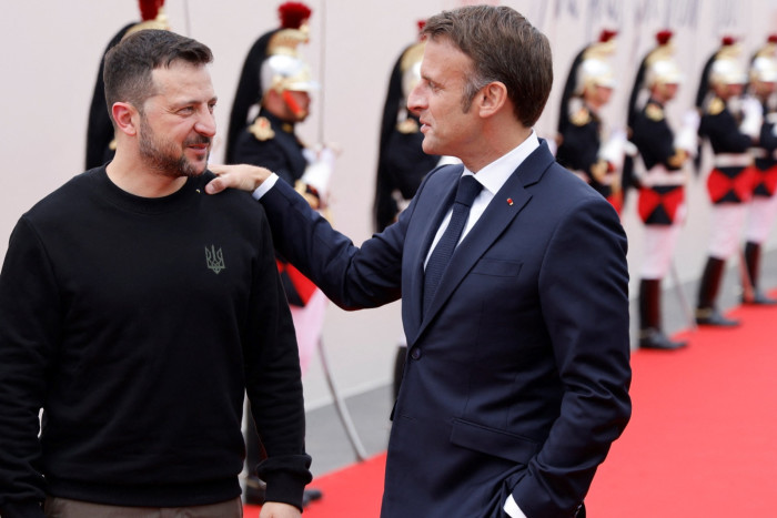 Emmanuel Macron, right, greets Volodymyr Zelensky at the commemoration of the D-Day landings at Omaha Beach in Normandy