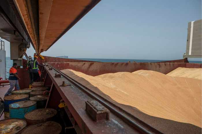 Maritime workers stand by grain onboard the Brave Commander bulk carrier ship