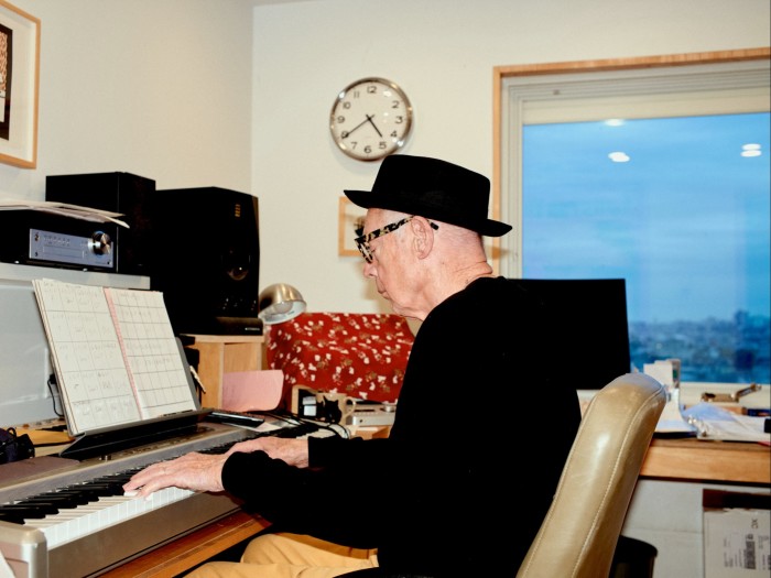 A man in a black hat plays a keyboard