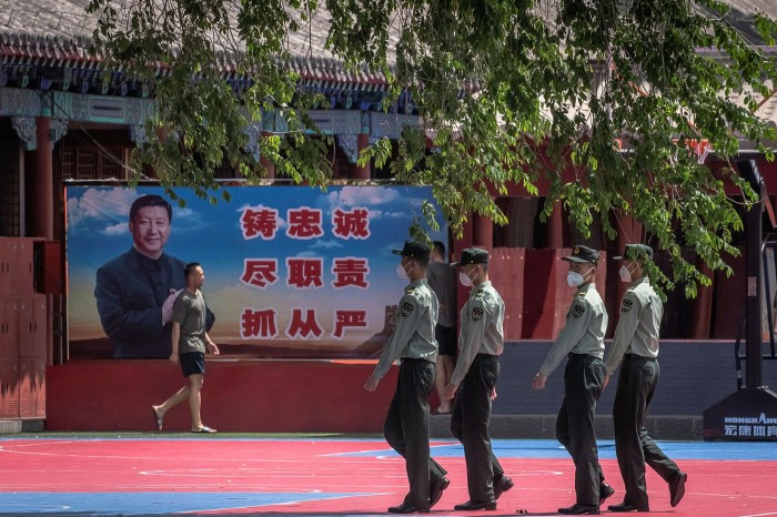 Chinese soldiers in Beijing march past a banner depicting Xi Jinping. After largely disappearing from view in late January, the president finally showed up on the front lines of the battle against coronavirus on February 10