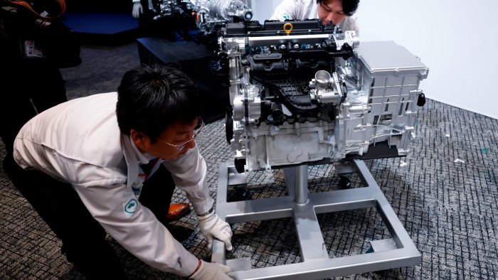 Toyota staff with a mock-up of Toyota Motor Corp.’s 1.5L in-line 4-cylinder engine 