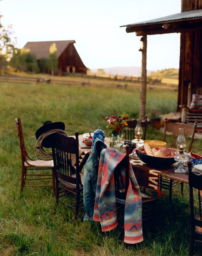 Dining outside the Vance Cabin on pressed-back chairs, and Navajo and American Trade blankets