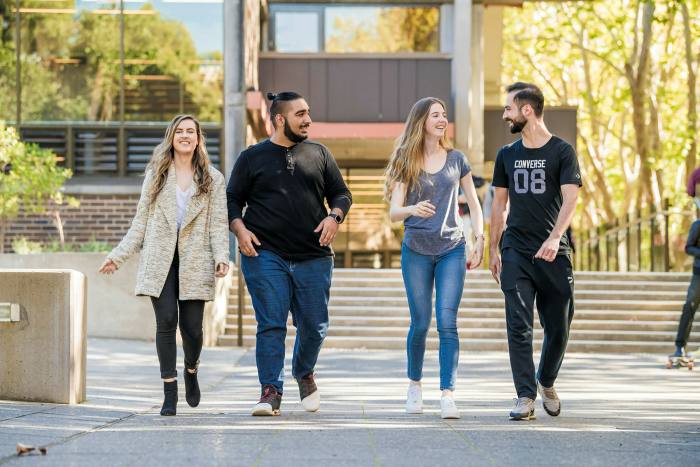four students walking together on campus