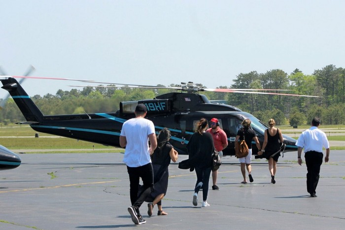Passengers cross the tarmac to board a helicopter