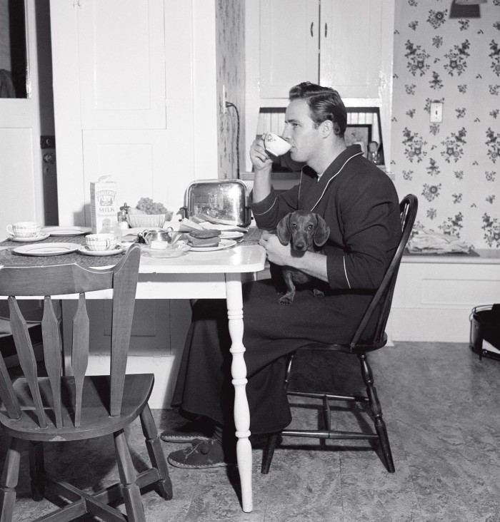 Marlon Brando having breakfast in a dressing gown and slippers in 1949