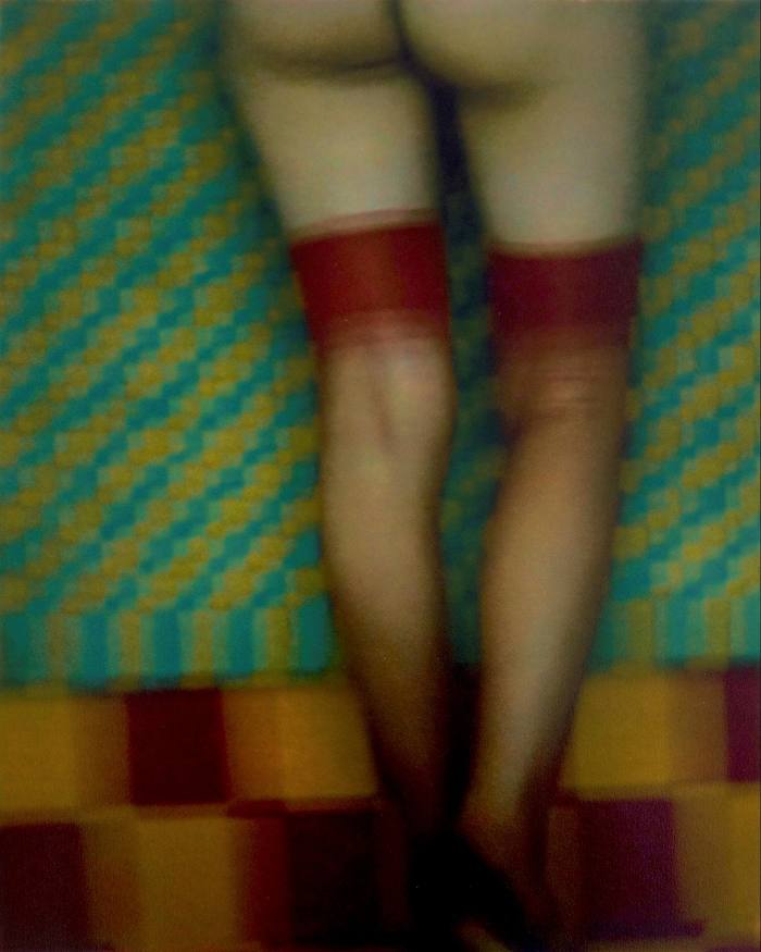 Blurry photo of a woman’s lower half seen from behind wearing nothing but stockings