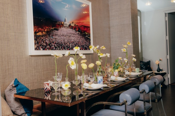 Her table decorated with Stories of Italy handmade glasses, Jung Lee New York handblown bud vases (holding poppies and ranunculi), Philippe Deshoulières plates, and vintage wine glasses. On the wall is a photograph of Obama’s inauguration by Stephen Wilkes