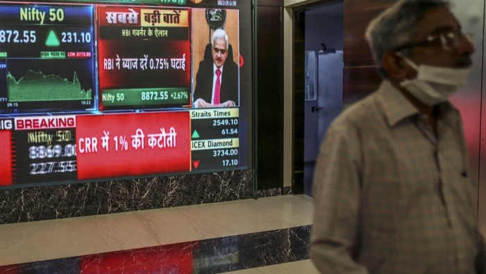 A screen displays a broadcast of the Reserve Bank of India governor Shaktikanta Das inside the Bombay Stock Exchange in Mumbai in March