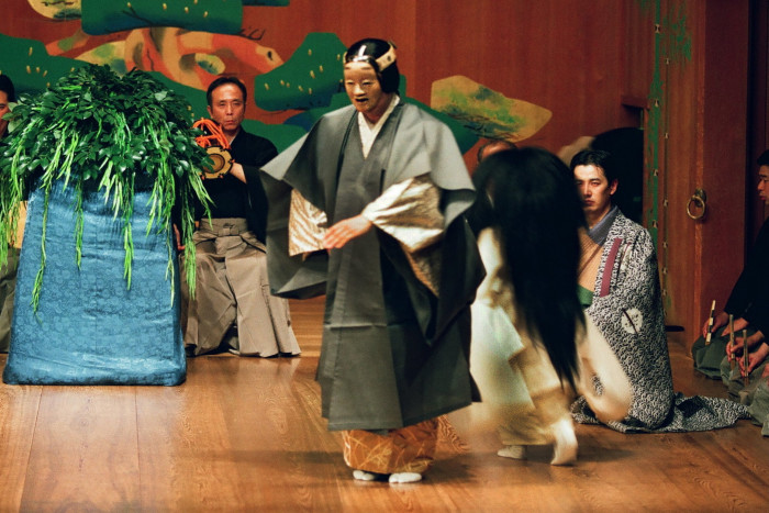 A group of Japanese Noh theatre actors perform on stage