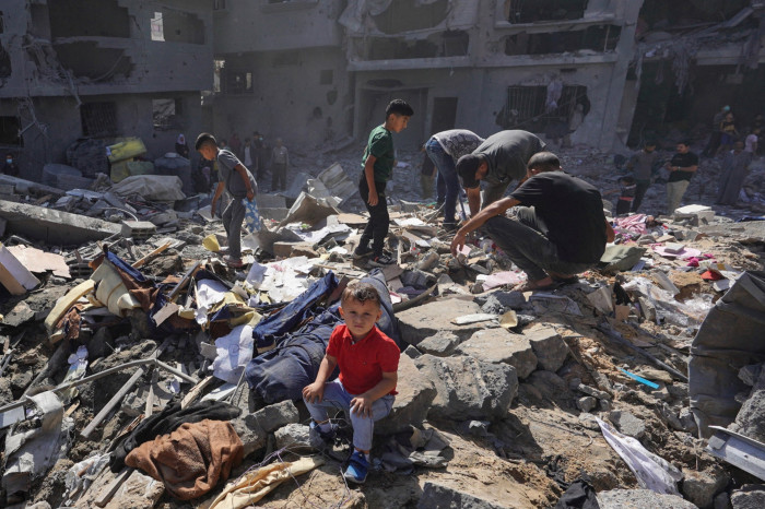 People searching through rubble after overnight Israeli strikes in al-Bureij refugee camp in the central Gaza Strip