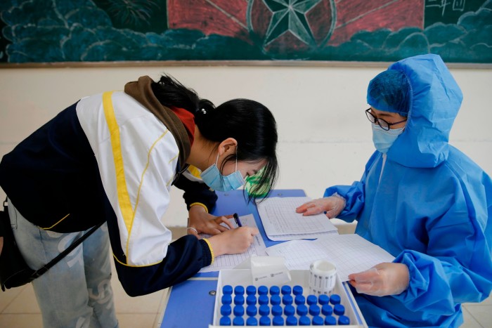 A student wearing a mask prepares to receive nucleic acid testing for the Covid-19 coronavirus at a high school in Harbin, Heilongjiang 