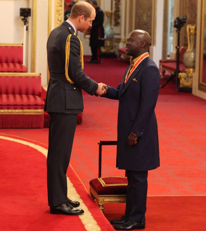 Prince William shakes hands with David Adjaye after awarding his knighthood