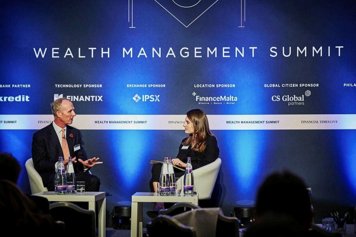 Madison Darbyshire discussing with a man during a wealth management summit