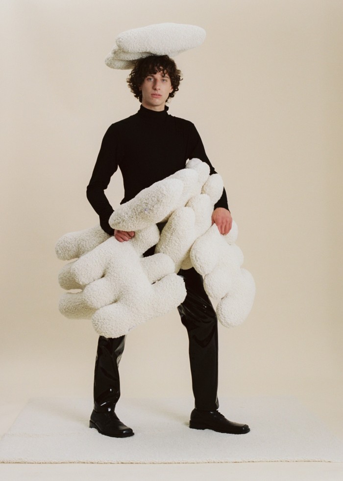 A clumsy Boucle cushion, $110, perches on a model’s head