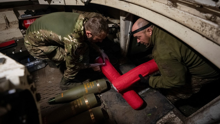 Ukrainian servicemen load shells into an M109 self-propelled howitzer