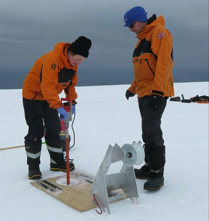 Liz Thomas operating a machine that gathers core samples, with another person beside her