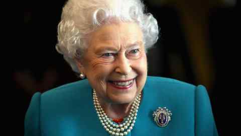 Queen Elizabeth smiling, wearing a turquoise dress with pearls and brooch