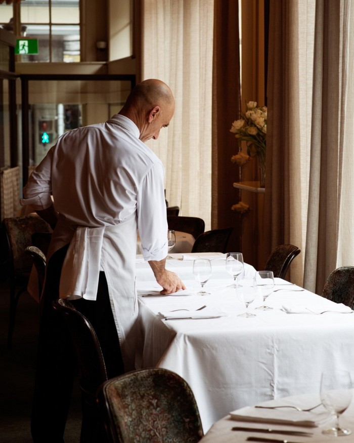 A waiter laying a table at Gimlet