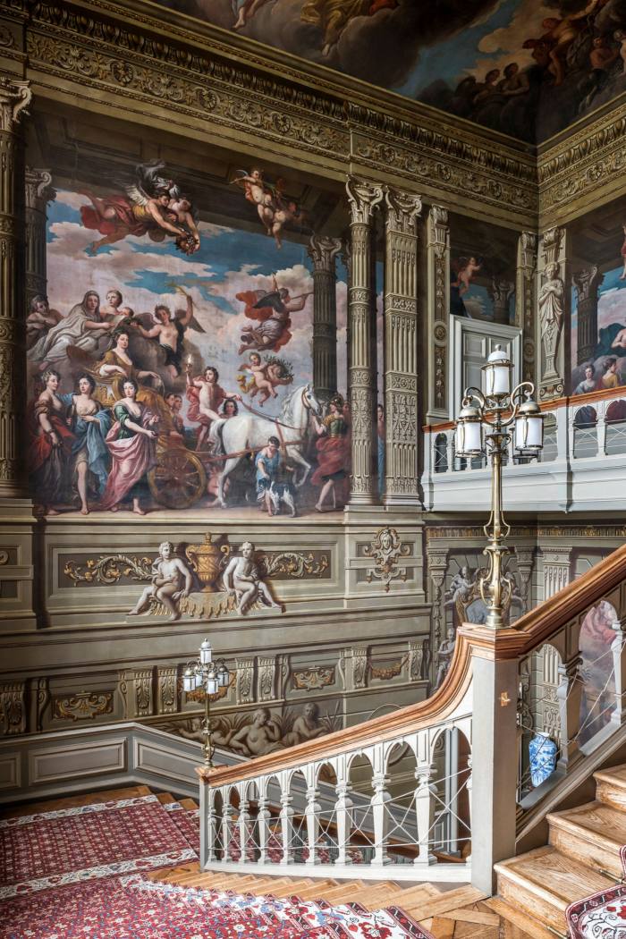 The Grand Staircase, with a view of Louis Laguerre’s 1720 mural of the Duchess of Somerset riding in triumph through the grounds of Petworth House