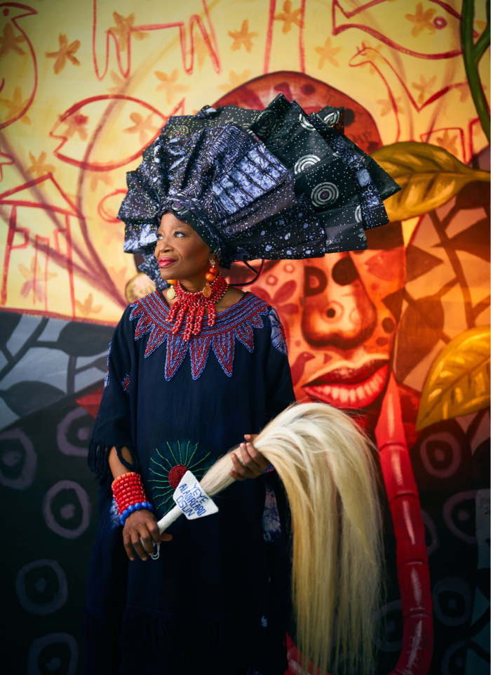 Photo of a smiling woman wearing a very large hemispherical black headdress