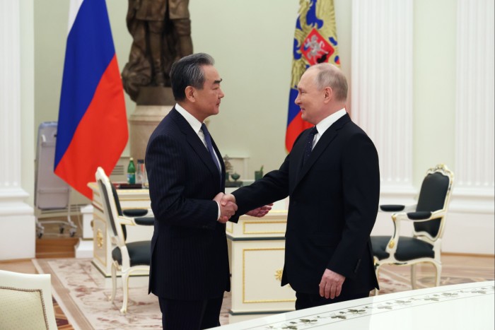 Russian leader Vladimir Putin shakes hands with Wang Yi, director of China’s Office of the Central Foreign Affairs Commission 