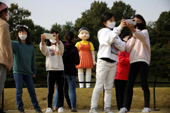 Visitors take selfies with a giant doll named ‘Younghee’ from the Netflix series ‘Squid Game’ at a park in Seoul, South Korea