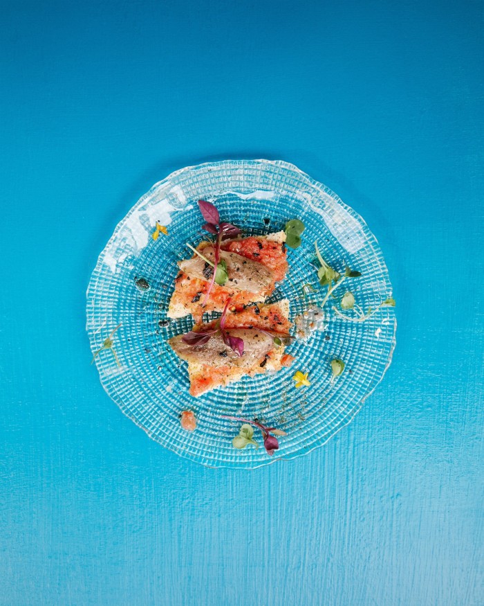 A fish tapas on a glass plate at La Concha