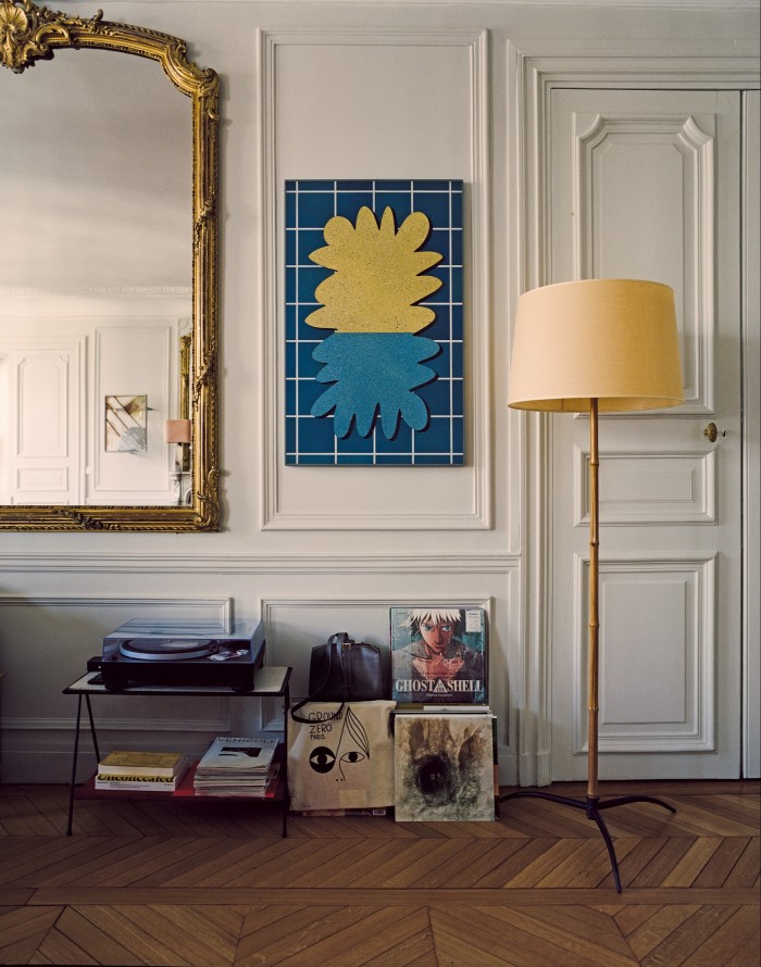 A Rhys Coren painting hangs above an Hermès Simone Hermès bag; in front of the door is a vintage French bamboo and bronze floor lamp
