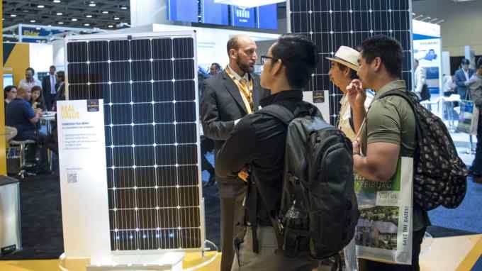 Attendees look at solar panels on display during the Intersolar North America Conference in San Francisco