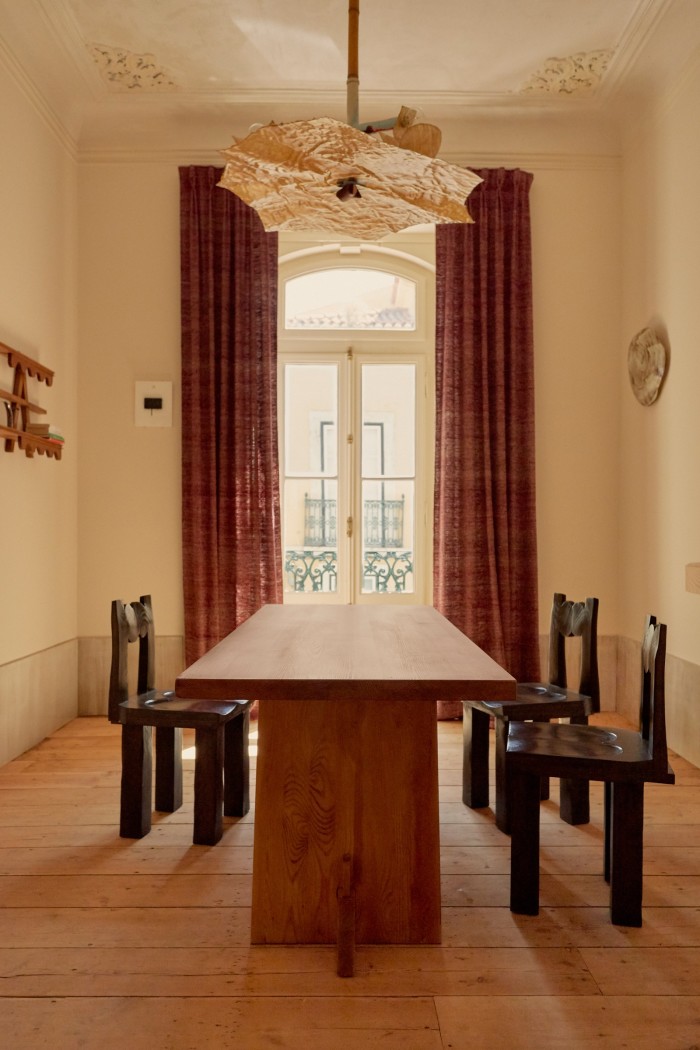 An Axel Einar Hjorth dining table, Minjae Kim chairs, Perrine Rousseau curtains and Garcé & Dimofski moon sconce in the dining room at Garcé & Dimofski gallery in Lisbon