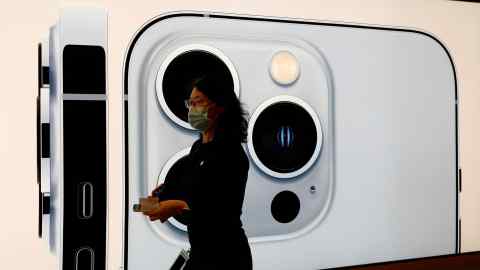 Woman in front of an image of an Apple iPhone