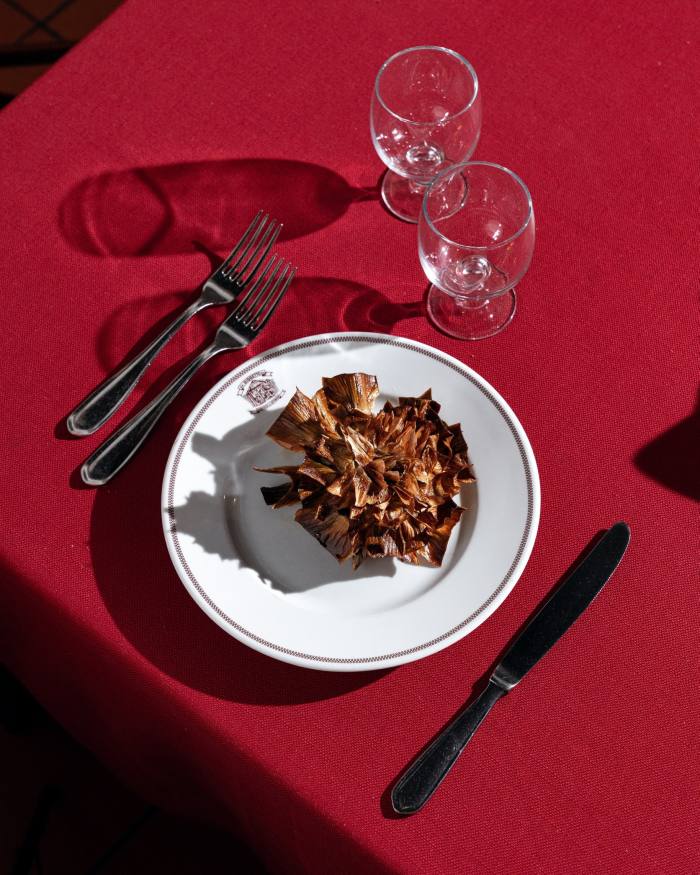 A plate of carciofi alla giudia on a red tablecloth 