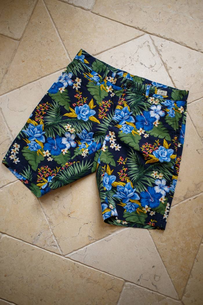 A pair of colourful swimming trunks on a tiled floor