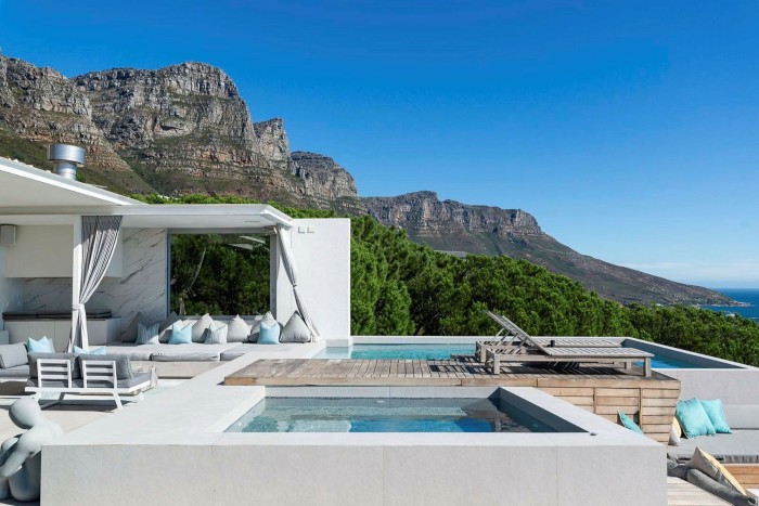 A contemporary house with an outdoor pool close to the foot of a mountain 