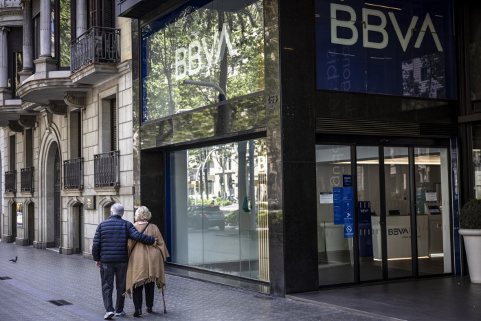 Pensioners pass a BBVA in Barcelona