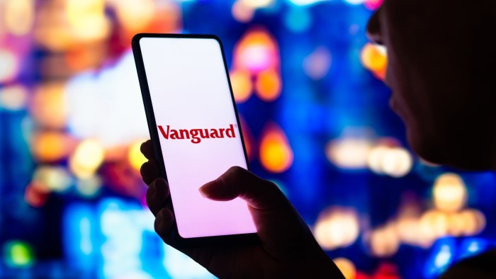 Woman’s hand holds smartphone with Vanguard logo on it