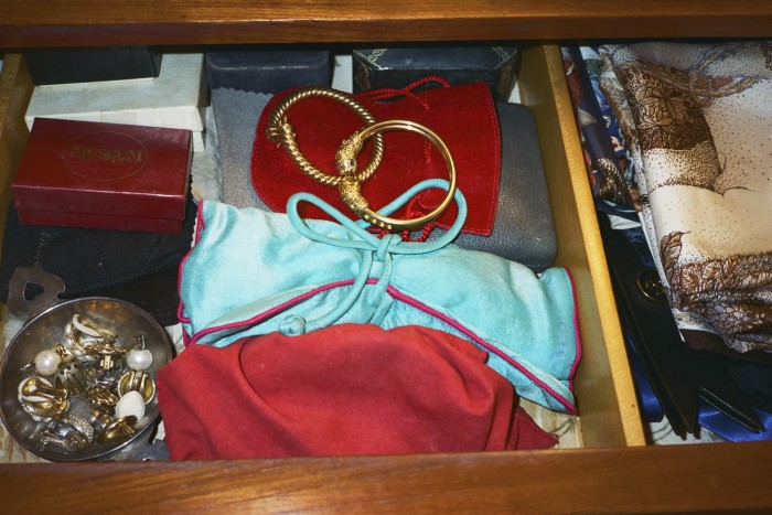 Jewellery in a drawer beside folded Hermès scarves
